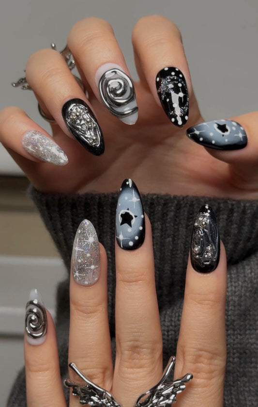 Noir Handmade almond-shaped nail art set with cosmic black and silver designs, featuring stars and swirls for a mystical look.