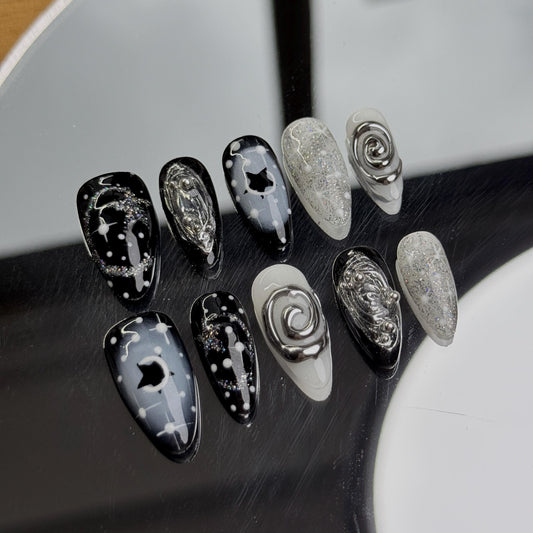 Noir Handmade almond-shaped nail art set with cosmic black and silver designs, featuring stars and swirls for a mystical look.