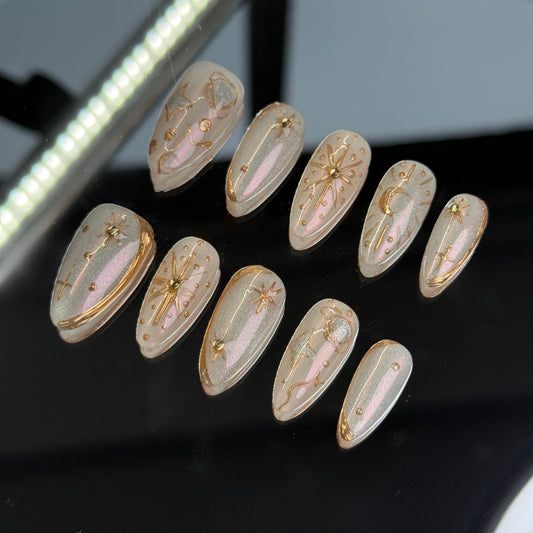 Celestial press on nail set with gold star and moon designs on nude shimmer base holiday vibes Christmas gift best nail for holiday cozy